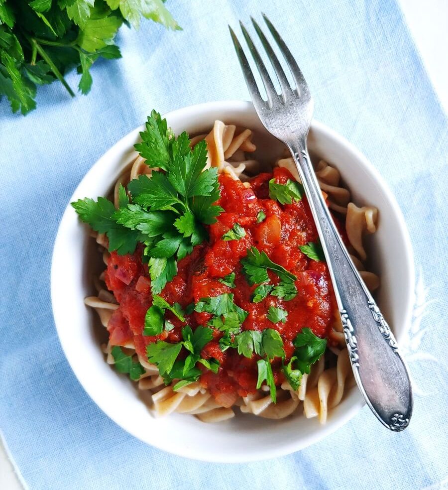 a bowl of pasta with tomato sauce and fork