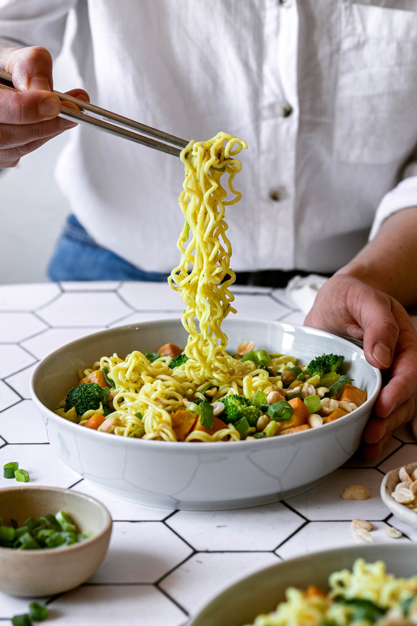 taking noodles out of the bowl of curry noodle soup with chopsticks