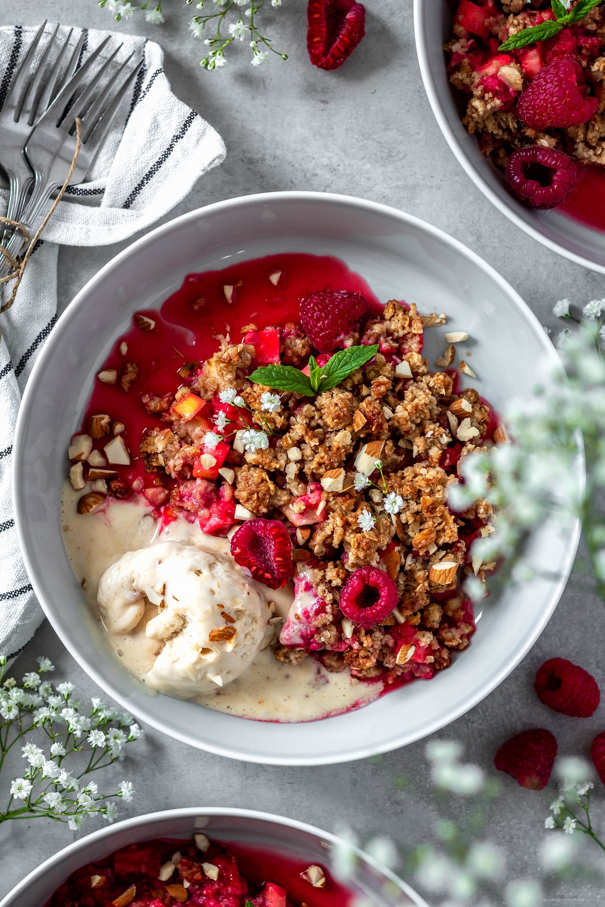 a plate full of simple vegan raspberry crumble with almonds and ice cream
